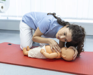 Nurse demonstrating infant CPR on a training doll