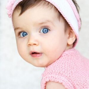 Blue-eyed baby wearing pink clothes