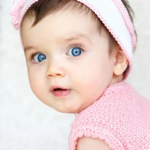Blue-eyed baby wearing pink clothes