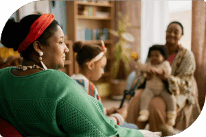 two mothers sitting with their children, smiling