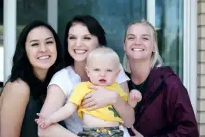 Three women interacting with a baby