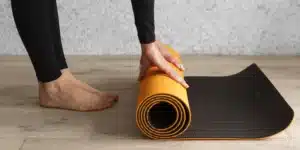 Woman rolling up yoga mat