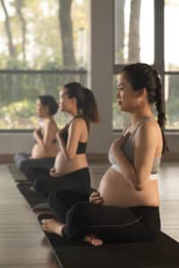 Three women practicing yoga in a line